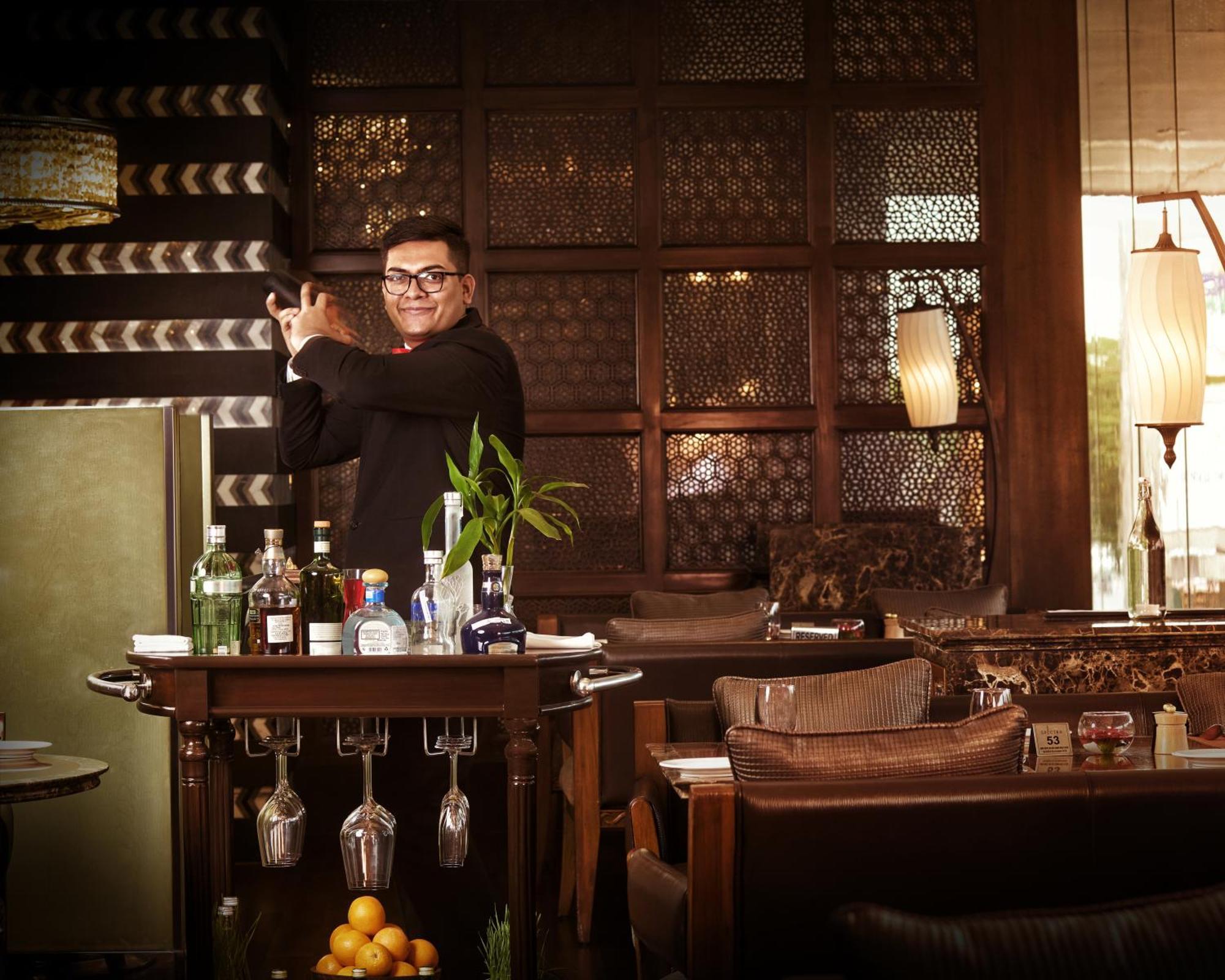 The Leela Ambience Gurugram Hotel&Residences Gurgaon Exterior foto A bartender at work